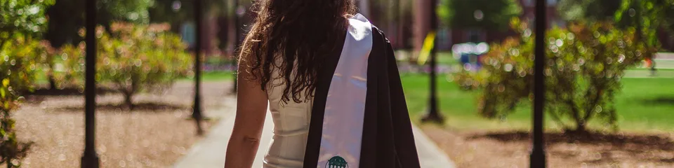 A new college graduate walks across campus – young workers facing fewer entry-level hires
